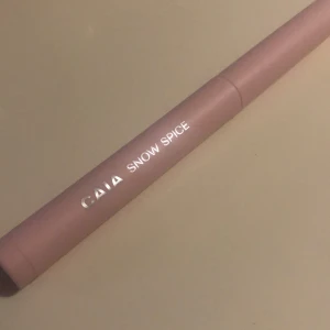 CAIA Snow Spice ögonskuggsstick - Krämig ögonskuggsstick från CAIA i nyansen Snow Spice. Färgen är en skimrande varm brons med guldiga glitterpartiklar. Pennan har en smidig, rundad form och kommer i ett stilrent ljusrosa hölje. Perfekt för att skapa en glowy look med ett svep. Tillhör Caia kalendern 2024 och är aldrig använd!
