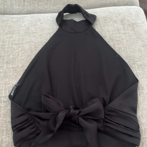 Svart halterneck topp Gina Tricot - Säljer denna svarta topp med öppen rygg och knyte i ryggen. Den är från finstrimlat i storlek 32💓