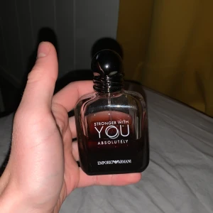 Emporio Armani Stronger With You - Emporio Armani Stronger With You Absolutely är en parfym i en stilren, mörkbrun glasflaska med rund svart kork. Flaskan har en modern och lyxig känsla med tydlig logga framtill. Perfekt för dig som gillar eleganta och maskulina dofter.