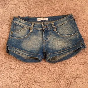 Blå jeansshorts från Fornarina - Snygga blå jeansshorts från Fornarina med  detaljer. Perfekta för varma dagar och enkel att matcha med allt. W27