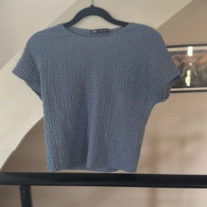 Blå strukturerad topp från Zara - Säljer en blå topp från Zara i storlek S. Toppen är helt ny och har aldrig använt den då jag inte tyckte den passa mig så bra