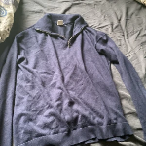 Mörkblå stickad tröja med half zip - Mörkblå stickad tröja med lång ärm och hög krage med half zip-dragkedja. Perfekt för lager-på-lager och chillare dagar. Enkel och stilren design som funkar till det mesta.