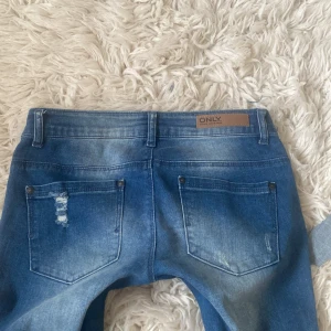 Super lågmidjade blåa bootcut jeans med slitningar - SÄLJER ÄVEN ETT PAR ANDRA LIKNANDE FAST I LJUSBLÅ💞 Superfina å ascoola blåa jeans med slitningar utsydda till bootcut! (Skriv för mer info/bilder på hur jag har sytt) Midja rakt över: ca 38,5 cm +stretch💞 Innerbensmått: ca 80,5 cm💞 (skriv för bild på mått för att se hur jag mätt) se sista bild för pytteliten defekt💞