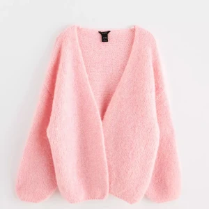 Rosa kofta Lindex  - Mysig rosa kofta från Lindex  i ett fluffigt material. Den har en öppen design utan knappar och långa ärmar. Tröjan är dock lite missfärgad och har en mindre ljus rosa färg (se bild). Tröjan passar mer som en S/M