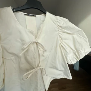 Topp med puffarmar - Vit topp från Gina tricot. Aldrig använd. 
