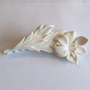 Vit hårklämma med blomdesign - Elegant vit hårklämma formad som en blomma med blad. Perfekt för att ge en stilfull touch till din frisyr. Klämman har en säker och stabil stängning.