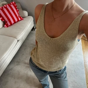 Guldglittrigt stickat linne - Säljer en snygg guldglittrig linnetopp med djup v-ringning. Köptes i somras i en liten butik i Italien men aldrig använd då jag har en liknande sen innan🤍Passar toppen både till vardags och till fest! Den är onesize men jag har normalt sett storlek S, skulle även passa både större och mindre!