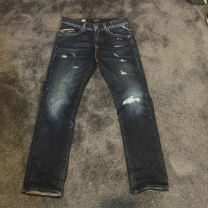 Blå jeans från Replay - Ass feta jeans från replsy med snygga slitningar. Står size 10A passar de som är typ 154-157. Väldigt bra skicke bara haft i typ 2-3 månader och säljer för de e för små nu. KOM MED PRIS FÖRSLAG
