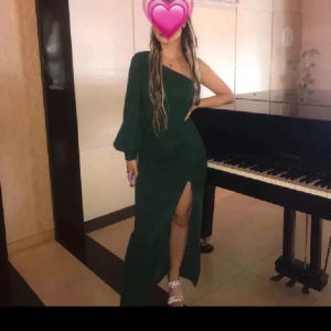 Grön långklänning med slits - Elegant grön långklänning med en djärv slits och en stilren oneshoulder-design. Perfekt för en kväll ute eller en speciell tillställning. Perfekta balklänningen❤️ Tjejen på bild xs/s och 1.58 lång för referens😁Köpt utomlands