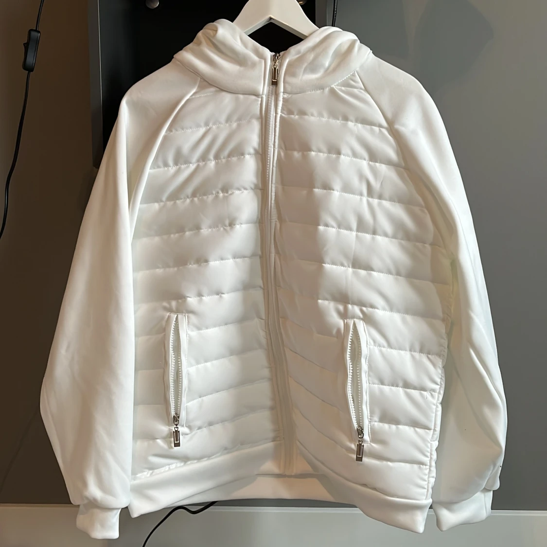 Säljer en vit cardigan med luva.