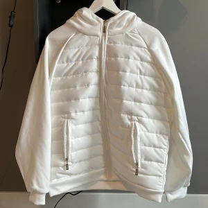 Säljer en vit cardigan med luva. - Säljer en helt oanvänd stilren vit cardigan med luva och är i storleken S.