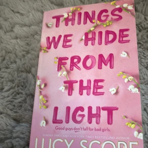 Things We Hide From The Light - En spännande roman av Lucy Score om polischefen Nash Morgan som kämpar mot brottslighet och sina egna känslor. När den frispråkiga Lina Solavita flyttar in bredvid, uppstår oväntade gnistor. En berättelse om hemligheter, kärlek och att hitta sig själv.
