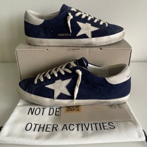 Golden goose skor - Ett par sjukt snygga golden goose skor i mörkblå mocka. De är knappt använda och har inga större tecken på användning. Med skorna kommer lådan, en påse och ett certifikat (syns på sista bilden). Skriv vid funderingar!