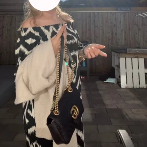 Svartvit offshoulder klänning - Svartvit mönster offshoulder klänning. Klänningen har trekvartsärmar och en lös passform, perfekt för en stilren look och varma sommardagar. Armarna går också att ha upp över axlarna om man skulle vilja de.