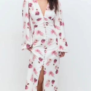 Blommig långklänning med v-ringning - Säljer nu denna superfina och trendiga adoore liknande klänningen från Gina Tricot. Aldrig använd och prislappen sitter kvar🤩Elegant långklänning med blommigt mönster i rosa och vinröda toner. Klänningen har en djup v-ringning och långa ärmar. Knappar framtill och en slits som ger en fin detalj.