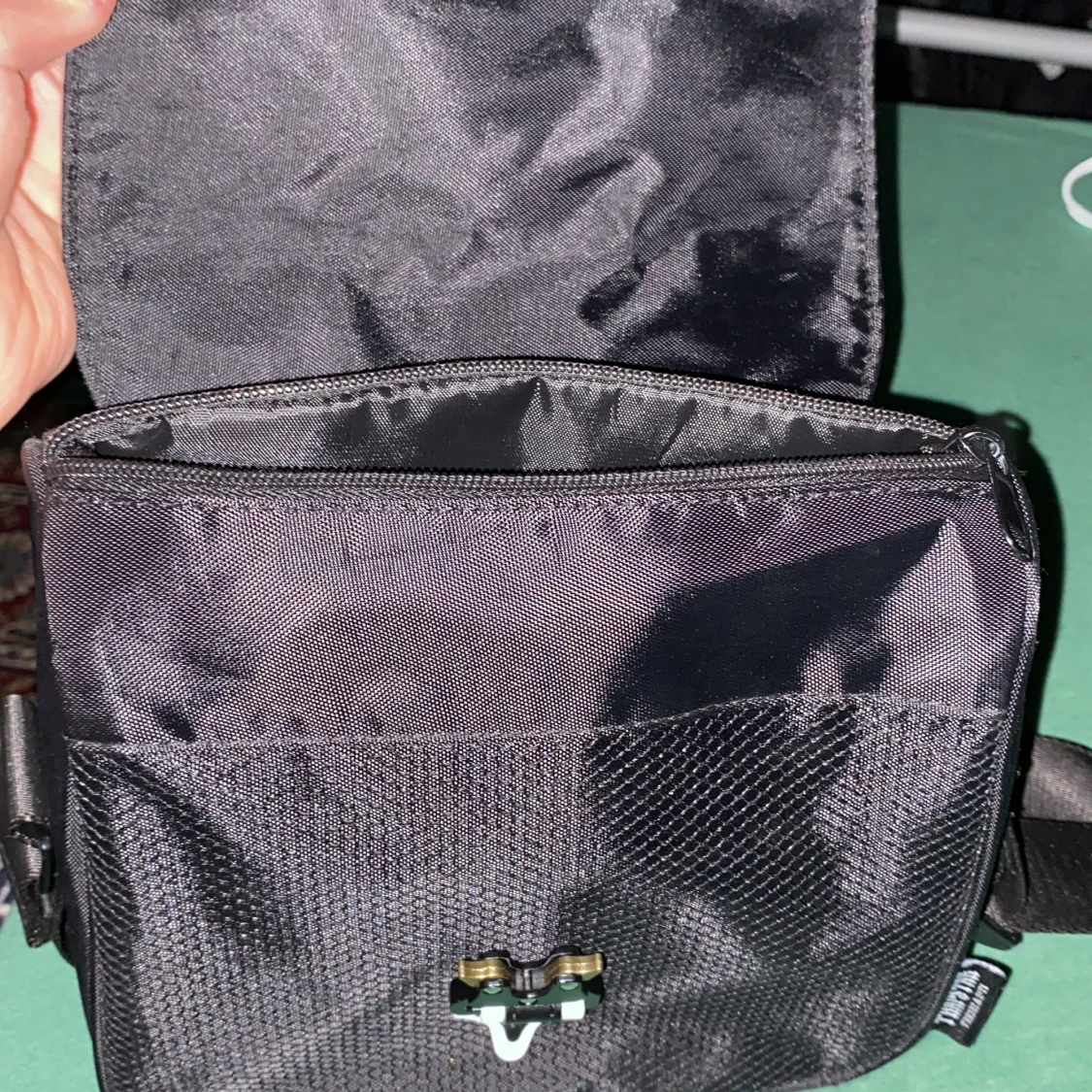 Svart axelväska med dekorativt emblem - 2