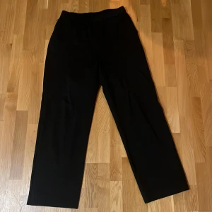 Svarta byxor från Nothing Something - Snygga svarta byxor från Nothing Something i storlek L. De har en elastisk midja med snörning. Borde passa dig som är 190 och uppåt 