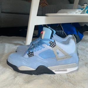 Ljusblå Nike Air Jordans - Säljer ett par ljusblå Nike Air Jordans i mocka med svarta och grå detaljer. Skorna har en klassisk snörning och en bekväm sula. Perfekta för dig som vill ha en stilren och sportig look.