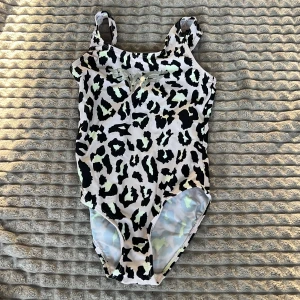 Leopardmönstrad baddräkt - Snygg leopardmönstrad baddräkt med smala axelband och en liten rosett framtill. Perfekt för en dag på stranden eller vid poolen. 🐆