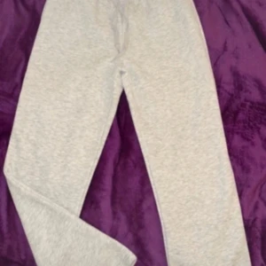 mjukisbyxor från Gina Tricot - Säljer ett par bekväma grå mjukisbyxor från Gina Tricot. Byxorna har en elastisk midja och är perfekta för en avslappnad stil. De är tillverkade i mjukt material som ger en skön känsla hela dagen.