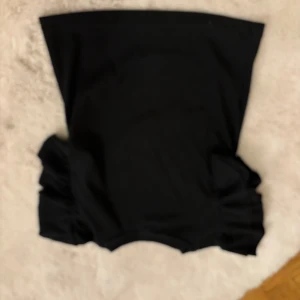 Svart topp från Gina Tricot - Säljer en stilren svart topp från Gina Tricot. Toppen har korta ärmar med volangdetaljer som ger en extra touch. Perfekt för att piffa upp vardagslooken eller för en speciell tillställning. 🖤