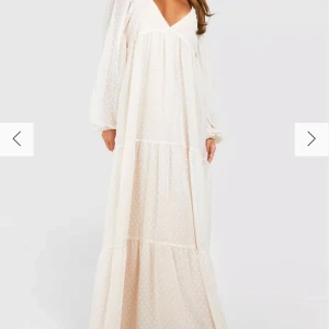 Beige långklänning från Boohoo - Säljer en elegant beige långklänning från Boohoo med prickigt mönster. Klänningen har en v-ringad design och långa ärmar, perfekt för en stilren look. Den är luftig och bekväm, idealisk för varmare dagar.