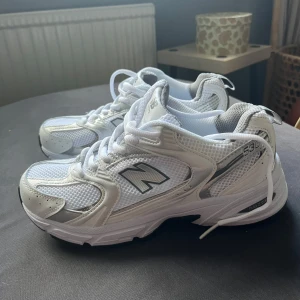 New Balance 530  - Snygga New Balance 530 sneakers i vitt och silver med mesh och syntetdetaljer. Skorna har klassisk snörning, ABZORB-dämpning och en chunky sula. Perfekta för dig som gillar sportig och trendig stil. Dessa är kopior, där av billigt pris. Helt nya aldrig använda.