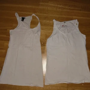 Vita linnetoppar från H&M & My Wear - Två klassiska vita linnetoppar, en från H&M och en från My Wear. Båda är ärmlösa med rund halsringning och raka snitt, perfekta att matcha med jeans eller shorts. Tillverkade i mjuk bomull som känns skön mot huden.