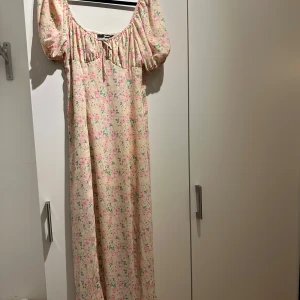 Blommig långklänning  - Långklänning från Bik Bok med blommigt mönster i rosa och grönt. 