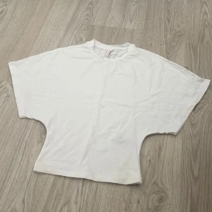 vit t-shirt blus med vida ärmar - enkel och stilren vit t-shirt med extra vida korta ärmar. t-shirten har rund halsringning.