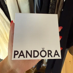Pandora silverarmband med hjärtlås - Snyggt och stilrent armband från Pandora i äkta silver. Armbandet har ett klassiskt runt band och ett lås format som ett hjärta, perfekt för att addera egna berlocker. Kommer i originalask och är en ikonisk accessoar för dig som gillar att uttrycka din stil. Aldrig använt då det kom som en gåva med annat köp!