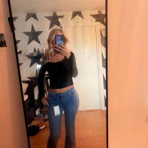 Blå bootcut jeans från Bershka - Säljer ett par nya snygga blå bootcut jeans från Bershka i storlek 34. 