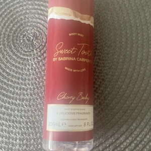 Sweet Tooth Cherry Baby Body Mist - Body mist Sweet Tooth Cherry Baby från Sabrina Carpenter. Flaskan är röd med gulddetaljer och rymmer 236 ml. Doften beskrivs som söt och sofistikerad, perfekt för dig som gillar fruktiga och godisaktiga toner. Snygg design med genomskinlig botten och guldtext.