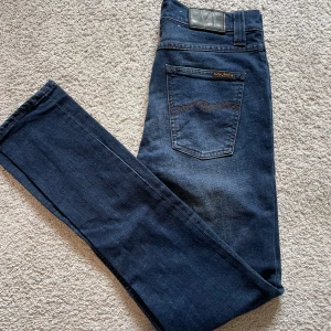 Nudie Jeans  - Snygga mörkblå jeans från Nudie Jeans Co med klassisk femficksdesign. Jeansen är i riktigt bra skick. Storleken är 28/32. Priset är ej hugget i sten🤗