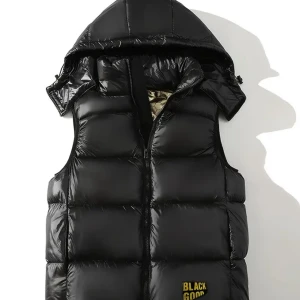 Svart dunväst med huva och gulddetalj - 🖤 Kamndens Black Vest Den perfekta kombon av lyxig design och urban attityd. Med glänsande svart finish, djärv siluett och detaljer som talar stil – är den här västen gjord för dem som inte följer trender… de sätter dem.  För folk med vision. För gatan. För dig. Kamndens – people wear power.