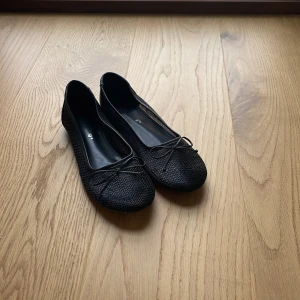 Svarta ballerinaskor med rosett - Jättefina svarta ballerinaskor från Asos! Jag tycker dessa är såå söta men tyvärr så passar de inte mig så bra, därför är de bara använda kanske 3-4 gånger. Tror att jag köpte de för runt 320kr men är osäker på om de fortfarande säljs🫶