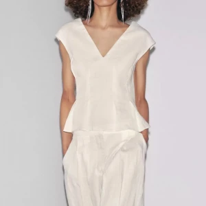 Vit linnetopp med v-ringning - Snygg vit linnetopp med v-ringad hals och korta ärmar. Slutsåld från Zara i storlek m men skulle säga att den passar s/m, superfint skick! 