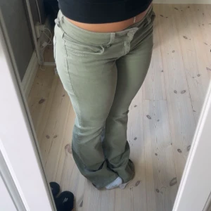 Olivgröna bootcut byxor från Nelly  - Snygga olivgröna bootcut byxor från Nelly med broderingsdetaljer på bakfickan. De är använda endast 2-3 gånger och är helt hela! 