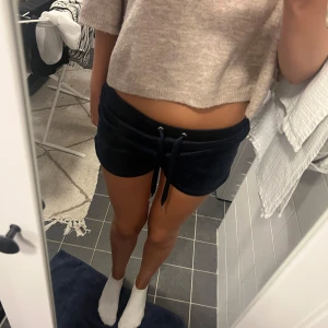 Mörkblå velourshorts med snörning - Supersköna mörkblå shorts i mjuk velour med bred resår i midjan och snörning framtill.