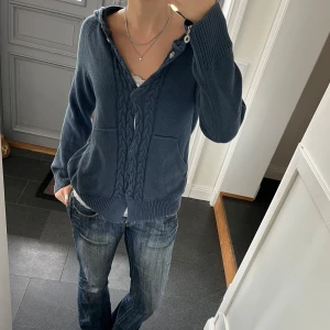 Blå stickad kofta  - Blå stickad kofta med luva från house of lola i storlek s/m. Fint skick. Använd gärna köp nu!