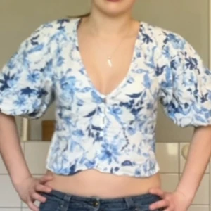 Hm blus med puffärmar och knappar - Fin blus från HM, storlek M, enda defekten är att Hm taggen inte sitter fast på ena sidan- se bild😊🫶 Blå, vit blomstrigt mönster