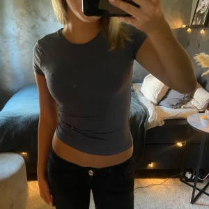 Marinblå gina t-shirt - Modellen är figurnära och passar perfekt till jeans eller kjol. Mjuk och skön i bomullsmaterial, perfekt för dig som gillar en clean och avslappnad look. Köpt för 169kr, aldrig använd 💕