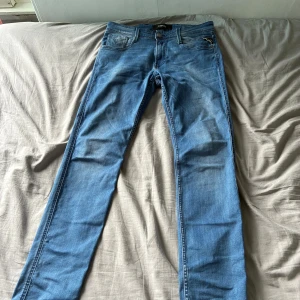 Feta nice blå replay jeans 30/34  - Snygga blå jeans från Replay med klassisk femficksdesign och raka ben. Jeansen har ljus tvätt och subtila slitningar för en avslappnad look. Tillverkade i mjukt bomullsmaterial med en skinnpatch bak i midjan. Perfekta för dig som gillar stilrena och bekväma jeans.