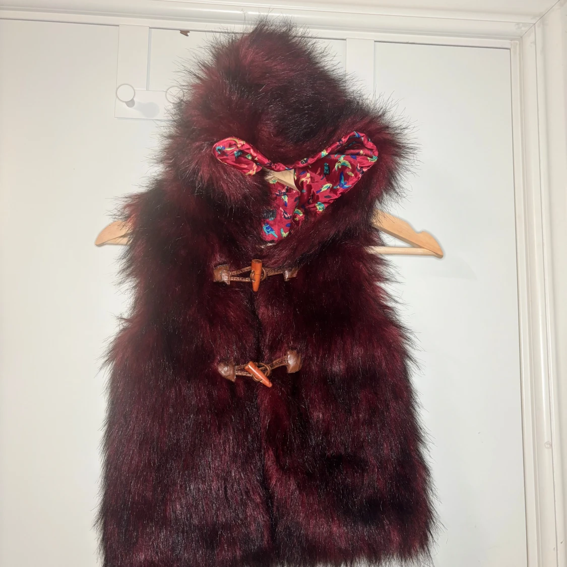 Vinröd pälsväst med huva från In Extenso