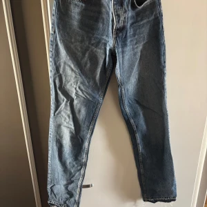 Zara lågmidjade  blå jeans straight fit - Klassiska  jeans i blå denim med raka ben och normal passform. Jeansen har fem fickor, knappgylf och tydliga sömmar. Perfekta för dig som gillar en tidlös och avslappnad stil.