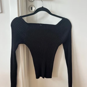 Svart ribbad långärmad tröja - Säljer en svart, ribbad långärmad tröja med tight passform och bred, fyrkantig halsringning. Skriv privat för mer bilder osv.