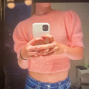 Stickad tröja - Superfin rosa croppad stickad tröja med korta puffärmar och rund hals. Tröjan har en mjuk och fluffig känsla, perfekt för dig som gillar en söt och trendig look. Passar perfekt till jeans eller kjol! PRIS KAN DISKUTERAS 