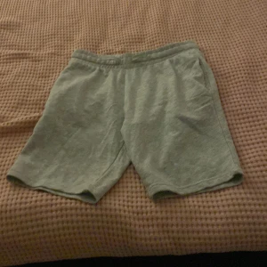Grå mjuka shorts från H&M - Gråa shorts från H&M i mjukt material med elastisk midja och sidfickor. Perfekta för chill dagar eller träning. Tillverkade i en mix av bomull, polyester och viskos för extra komfort. Enkel och stilren design som passar till det mesta.