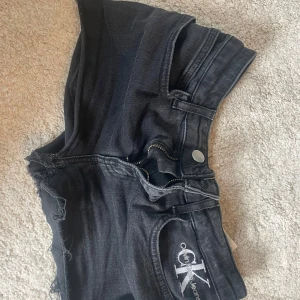 Svarta jeansshorts Calvin Klein - Svarta jeansshorts från Calvin Klein med råa kanter och klassisk femficksdesign.