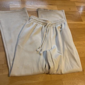 Vita mjukisbyxor med snörning XS - Säljer ett par vita mjukisbyxor i storlek XS med elastisk midja och snörning. Byxorna har raka ben och är tillverkade i mjukt material, perfekta för chill dagar eller när du vill vara bekväm. Snygg och enkel design som passar till det mesta.